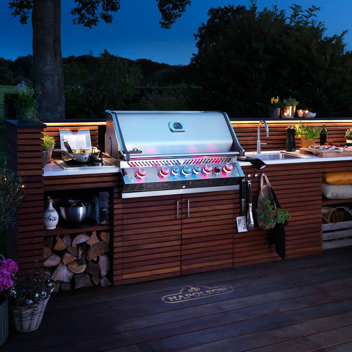 Napoleon Prestige PRO 665 Built-In at dusk with its control knobs glowing