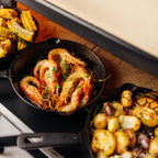 Prawns and potatoes roasting in cast iron pans inside the Gozney Dome XL (Gen 2)