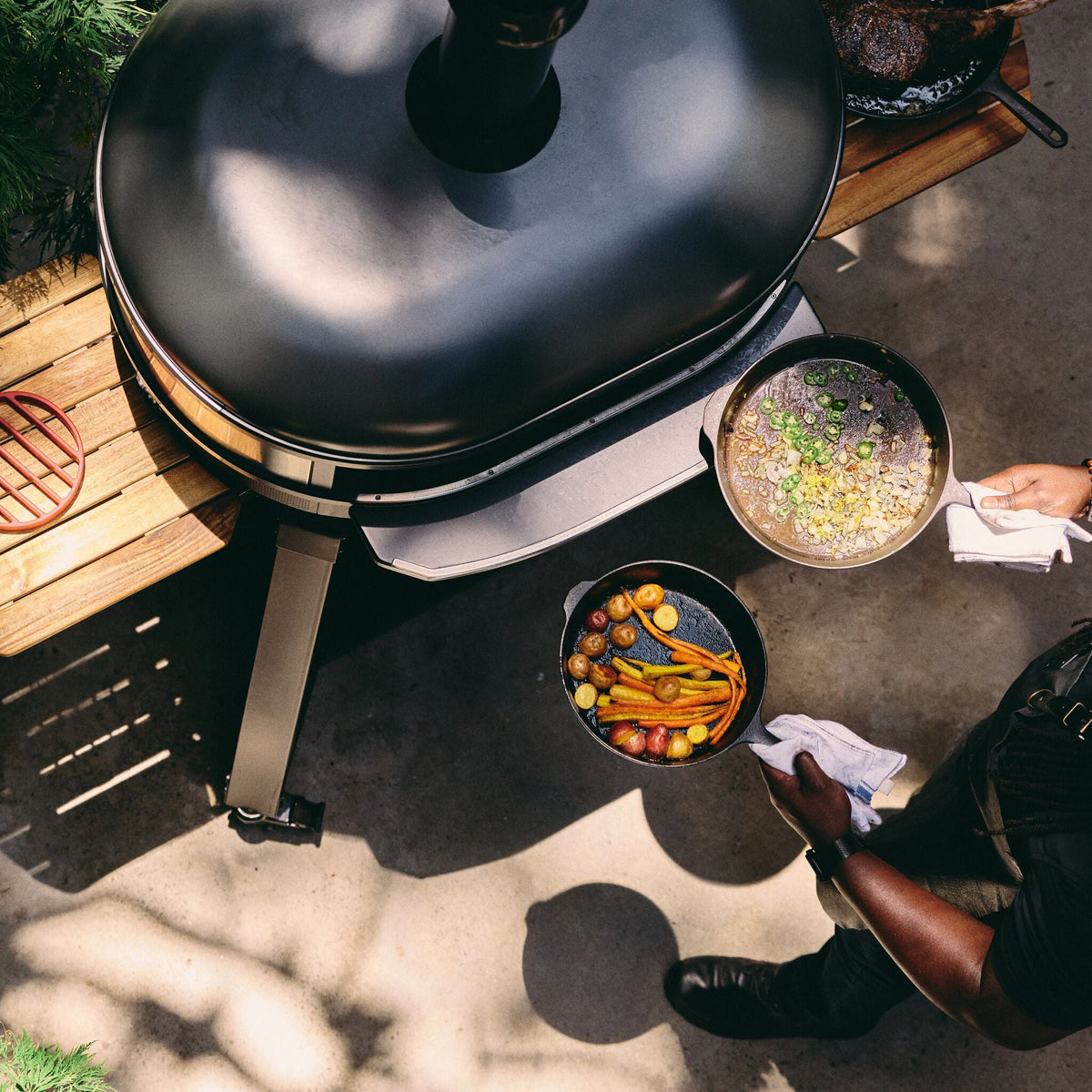 Overhead view of food being cooked in pans with the Gozney Dome XL (Gen 2)