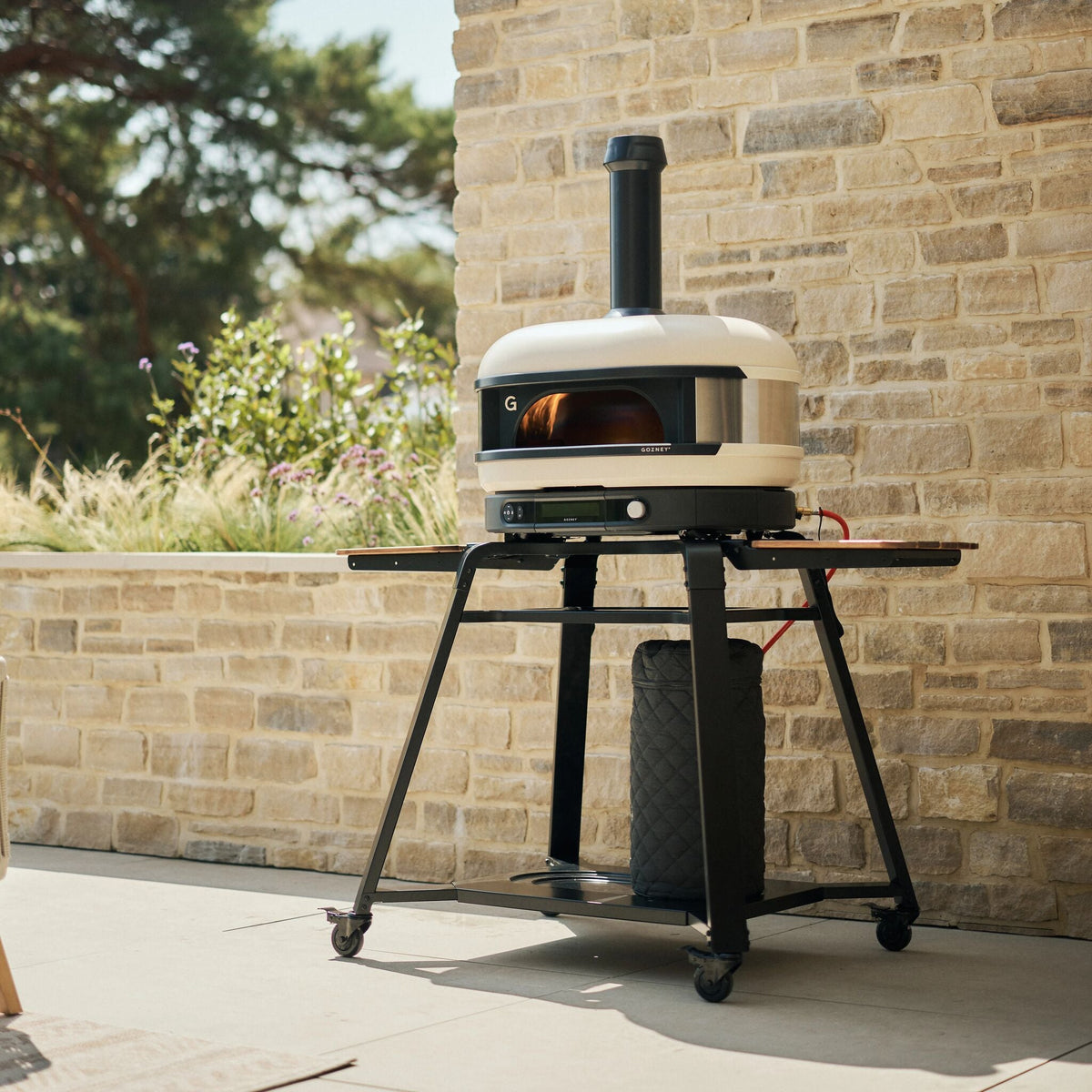 Gozney Dome (Gen 2) in Bone on a stand on a garden patio