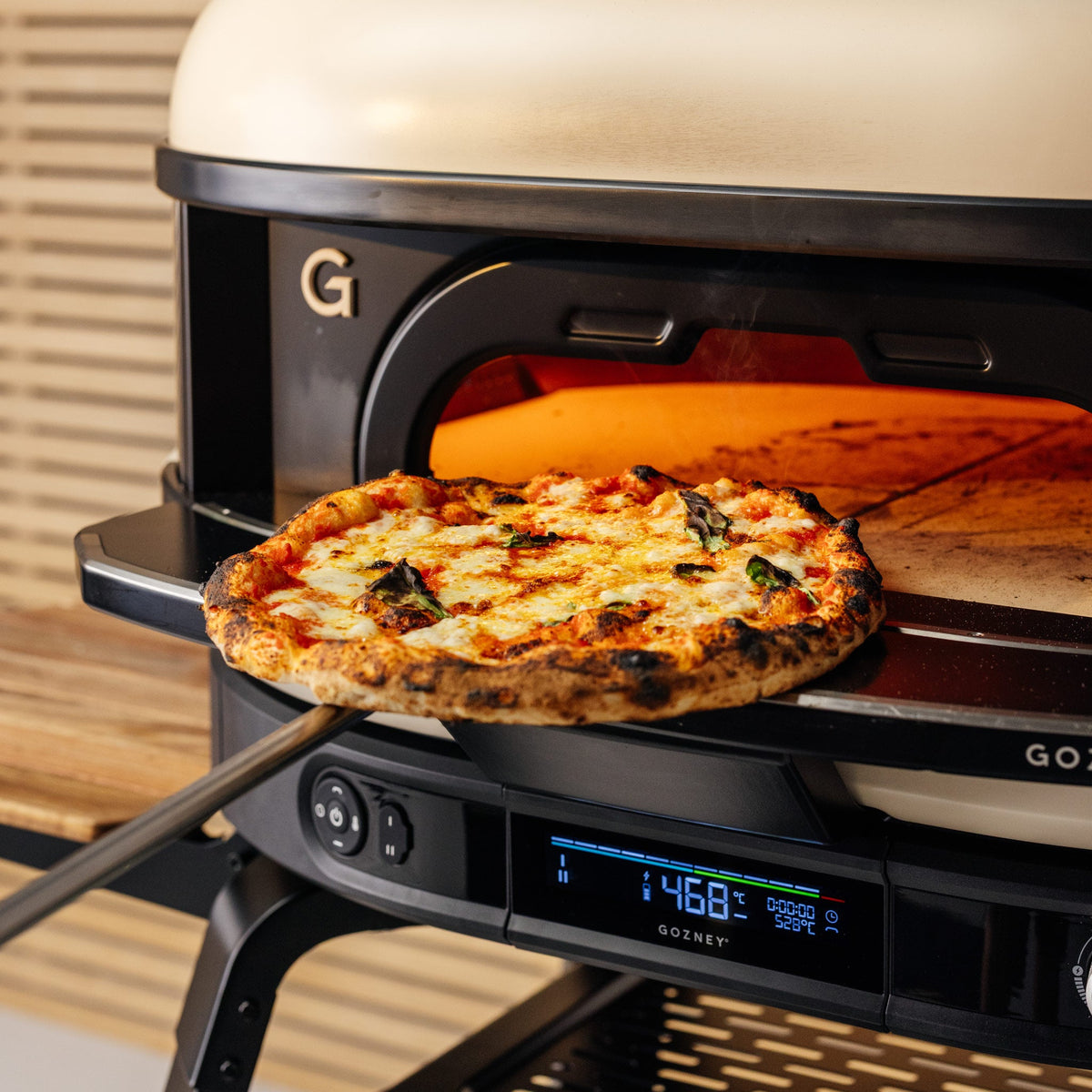 Pizza being launched into the Gozney Dome (Gen 2), with the digital temperature display below