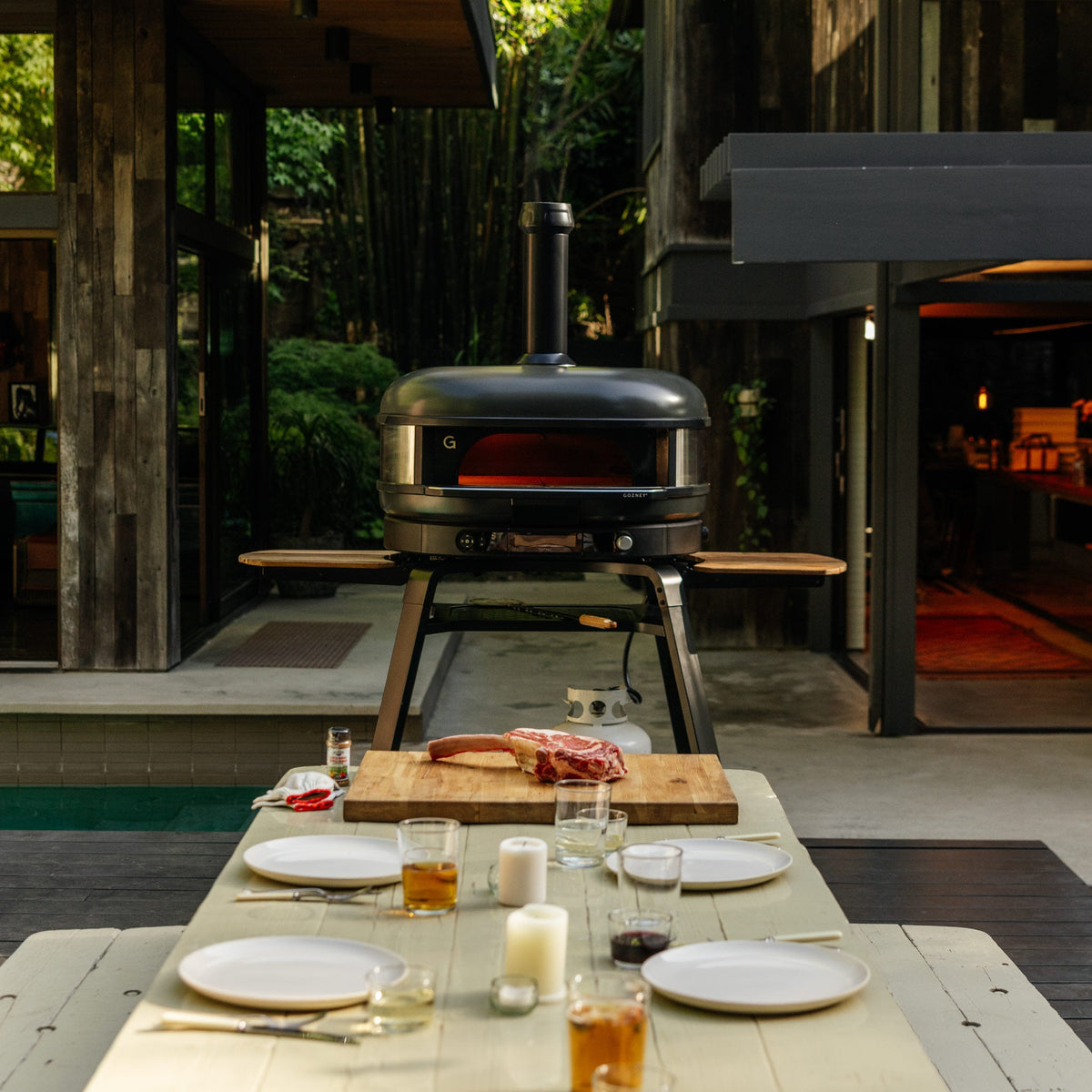 Gozney Dome XL (Gen 2) in Off Black at the head of an outdoor dinner table