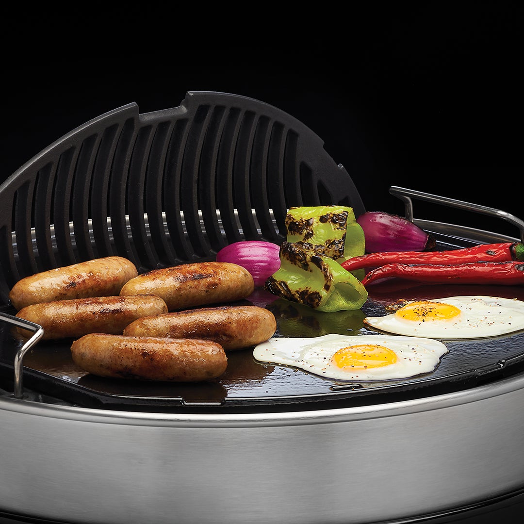 Sausages, eggs and vegetables on the Napoleon cast iron griddle in a charcoal kettle