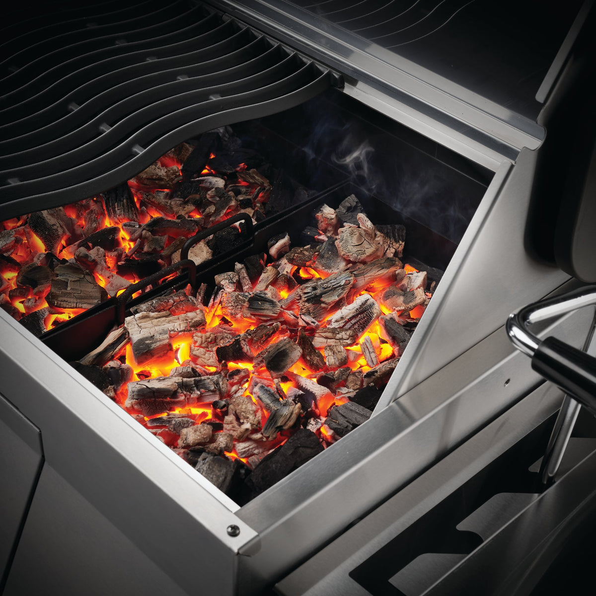 Glowing charcoal in the tray of the Napoleon Professional 605
