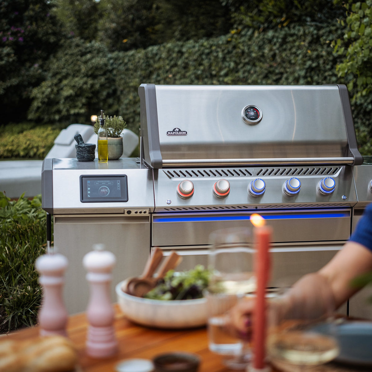 Napoleon Prestige PRO665 Elite Smart on a patio, with its touchscreen controller on the side shelf