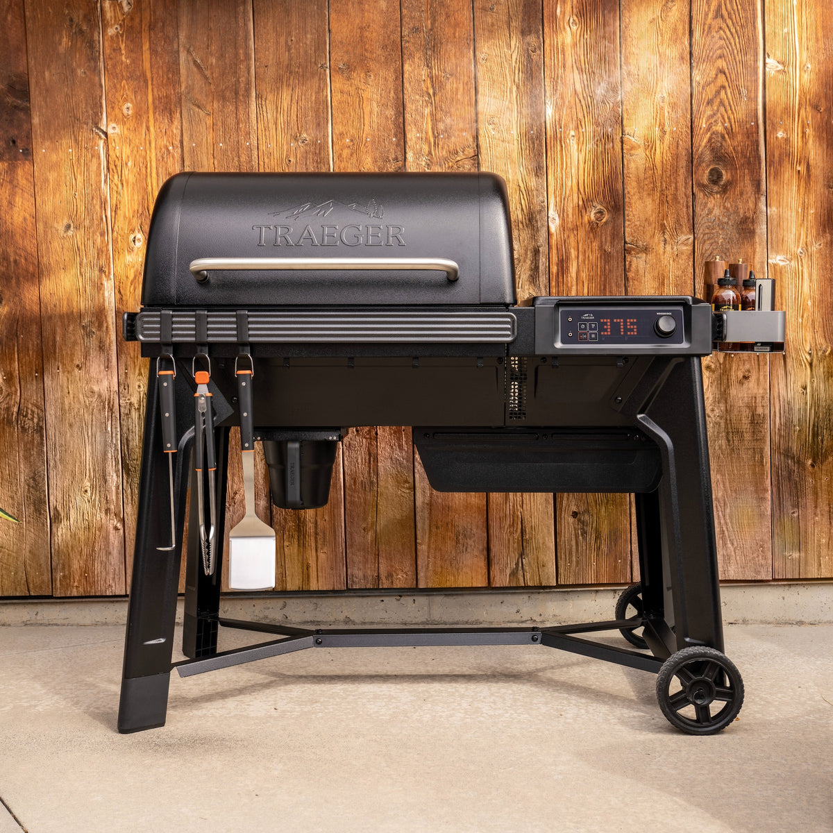 Traeger Woodridge wood pellet grill on a patio with accessories