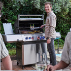 Man grilling for friends on the Napoleon Prestige 500 Connected Gas BBQ