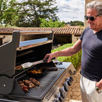 Man grilling meat and kebabs on the Napoleon Prestige 665 Connected Gas BBQ