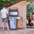 Man cooking on the Napoleon Rogue PRO 425 SIB while friends sit at a table