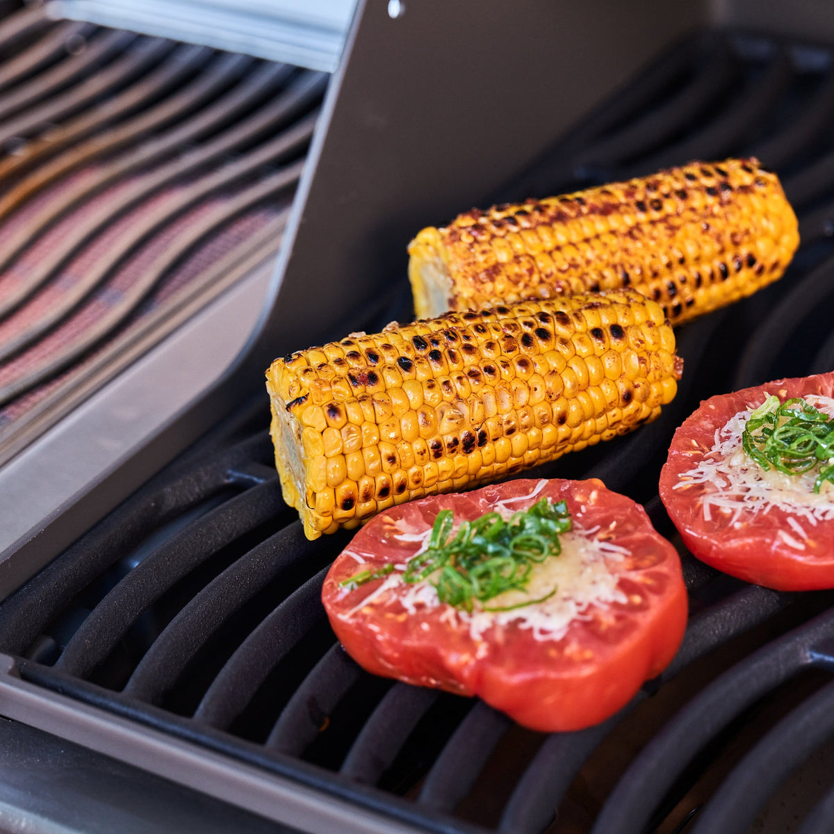 Corn on the cob and stuffed tomatoes grilling on the Napoleon Rogue PRO 425 SIB